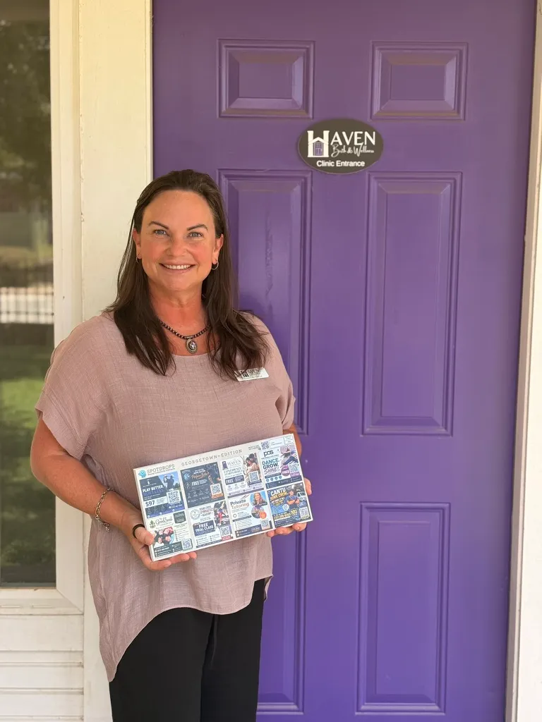 A customer at Haven holding Dustin’s SpotDrops Georgetown postcard
